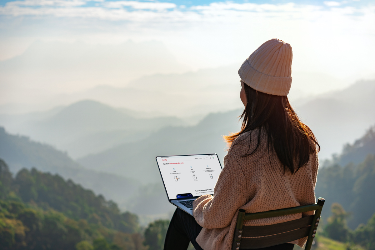 donna con laptop in montagna